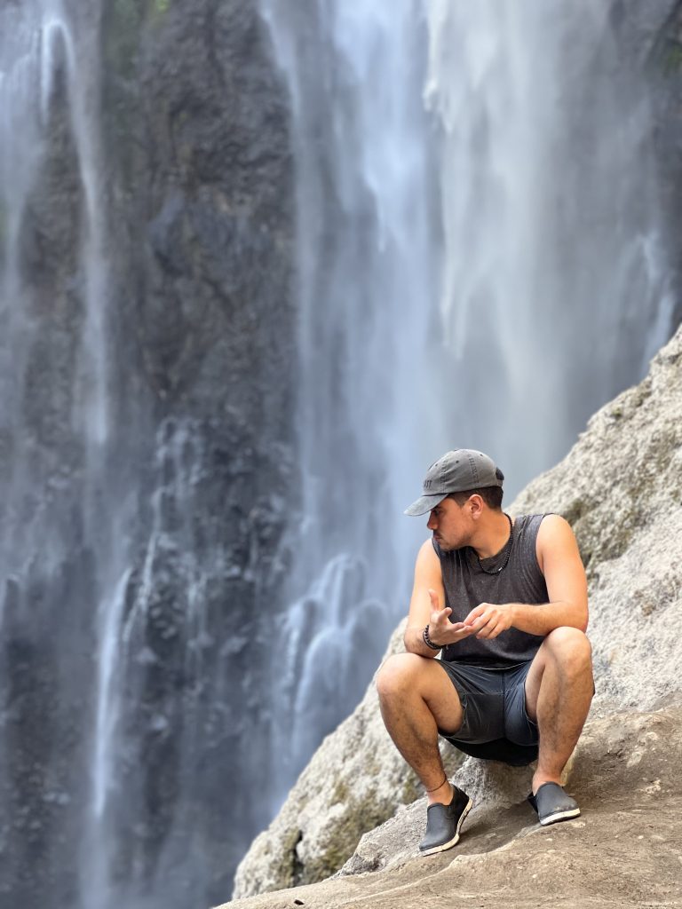 Sentado en la base de tumpak Sewu Waterfall, en East Java, Indonesia
